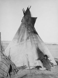 679px-oglala_girl_in_front_of_a_tipi2